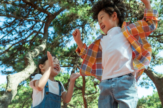 小女孩鼓励小男孩玩独木桥