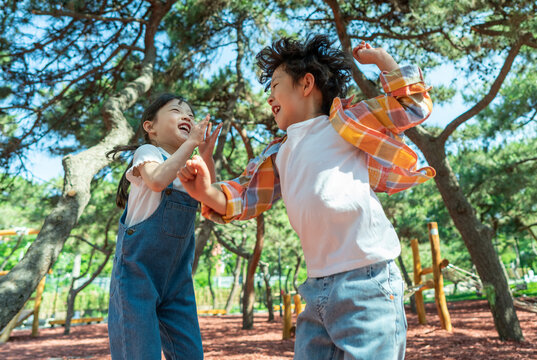 小女孩鼓励小男孩玩独木桥