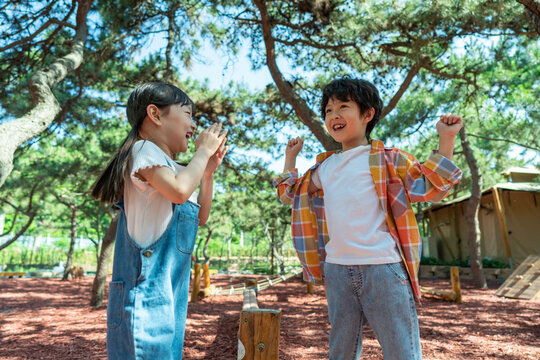 小女孩鼓励小男孩玩独木桥