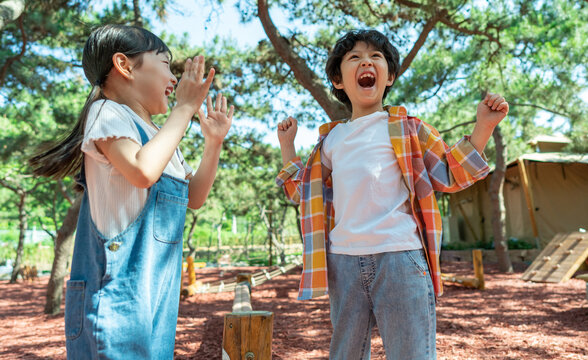 小女孩鼓励小男孩玩独木桥