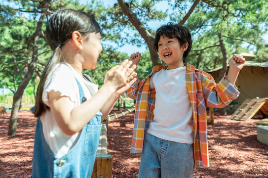 小女孩鼓励小男孩玩独木桥