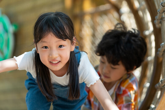 两个小孩子勇敢钻绳洞