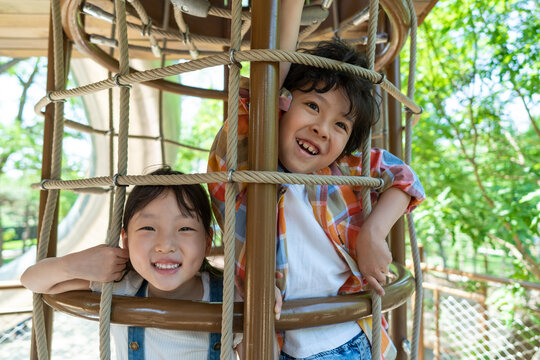 两个小孩子开心爬绳网攀爬架