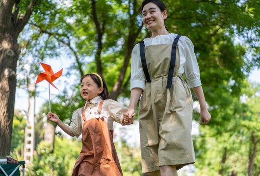 妈妈拉着女儿的手开心向前奔跑