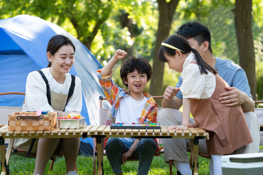 一家四口在露营地玩游戏开心欢呼庆祝