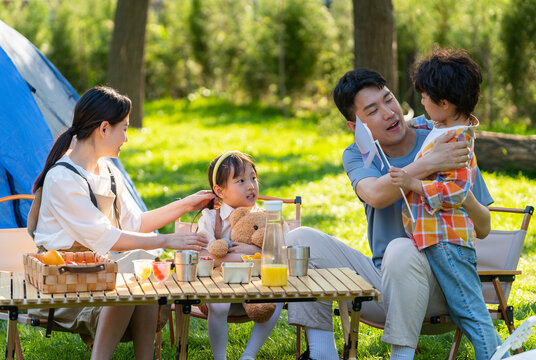 一家四口在露营地野餐孩子奔跑打闹