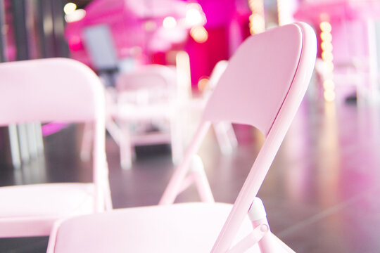 白色折叠椅粉色背景