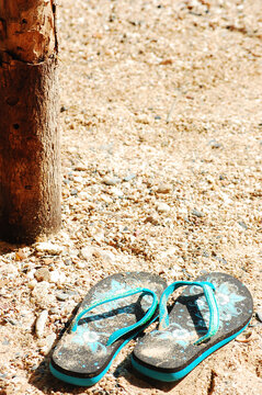 沙滩上一双绿色的人字拖鞋