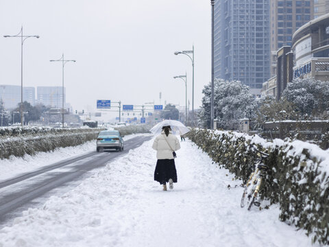 冬天城市大雪积雪的行人车辆道路