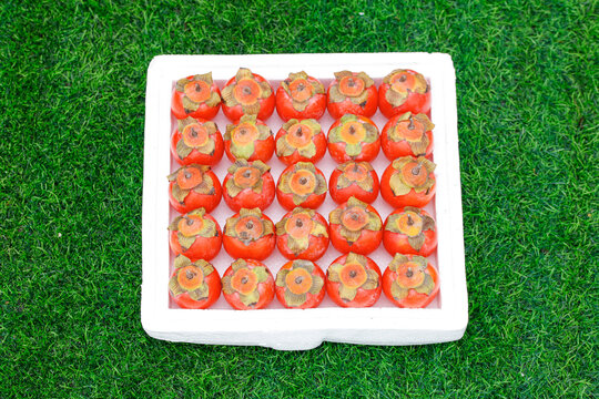 草地上放着一盒蜜柿