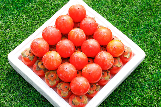 草地上放着一盒蜜柿