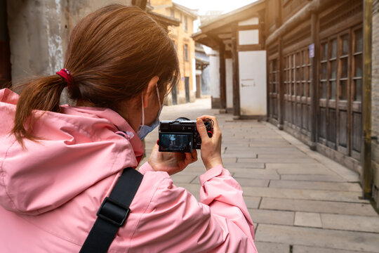 亚洲女性在街道上拍照背影