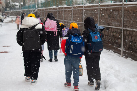 下雪天放学回家的孩子背影