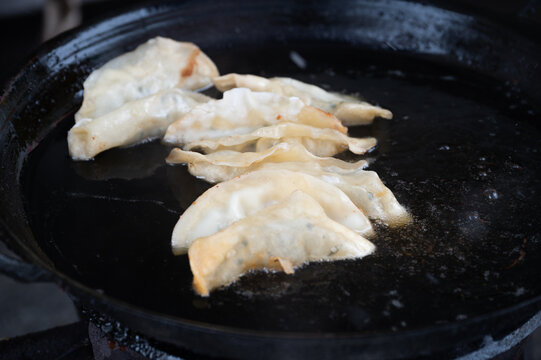 黑色煎锅里的几个煎饺常德锅饺