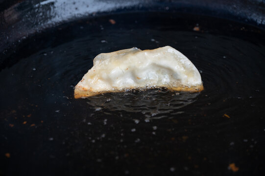 黑色煎锅里的一个煎饺常德锅饺