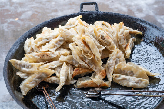 黑色煎锅里的一堆煎饺常德锅饺