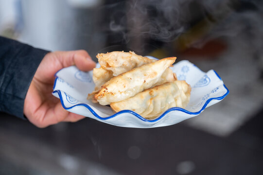 手里端着一盘煎饺常德锅饺