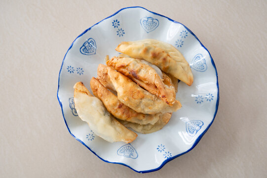 浅色桌面上一盘锅饺煎饺特写