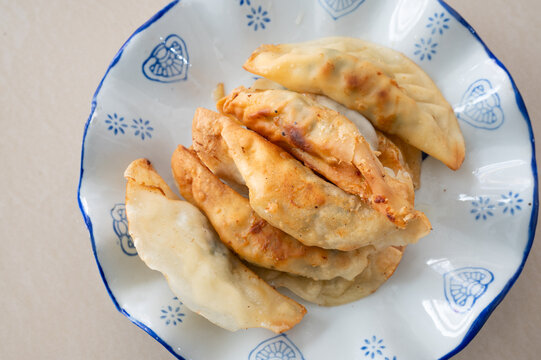 浅色桌面上一盘锅饺煎饺特写