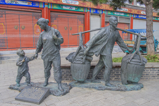 男人挑行李女人牵小孩群雕像