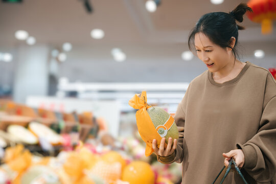 超市挑选新鲜水果的女人素材