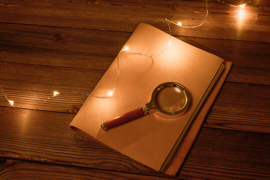 木桌上带放大镜和书的高角度视图