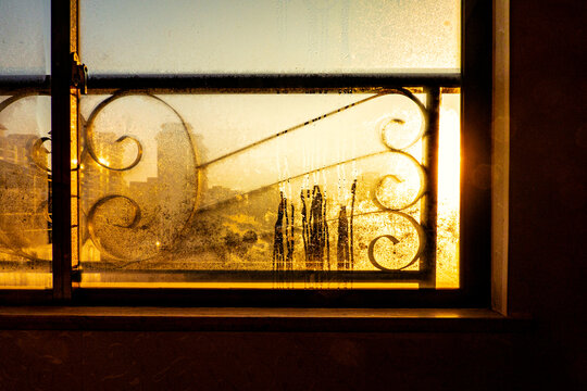 城市朝阳照在铁栏窗上
