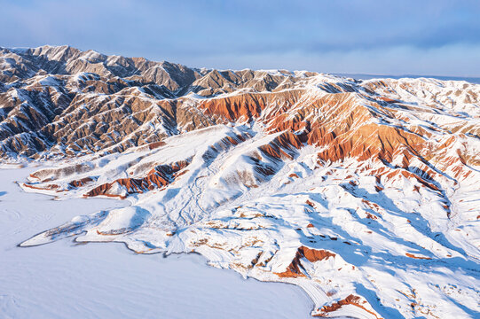 航拍嘉峪关黑山湖旁丹霞地貌雪景