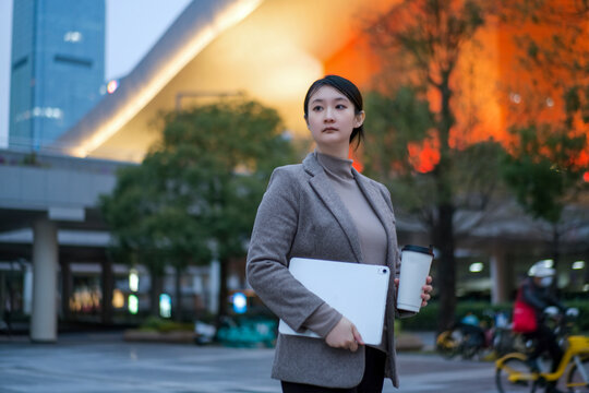 年轻女子行走在城市景观夜色中