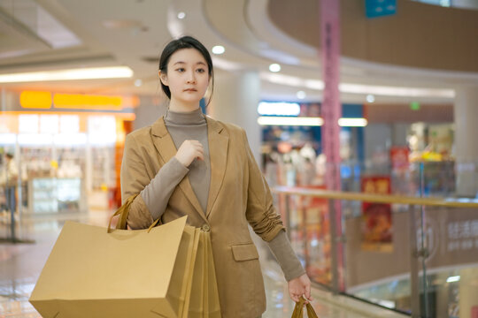 商场年轻女性提着高端购物袋