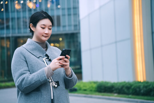 在城市景观中的自信女性查看手机