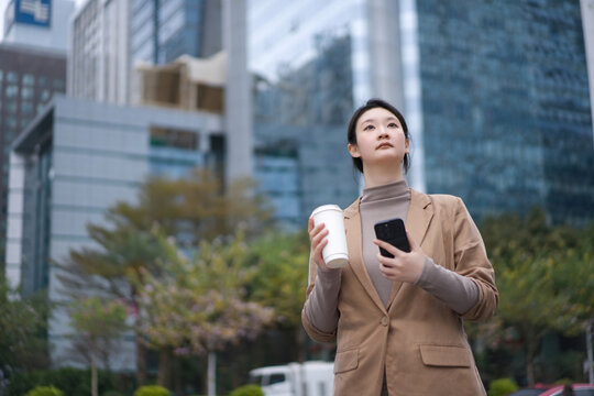 自信女性在办公楼外茶歇