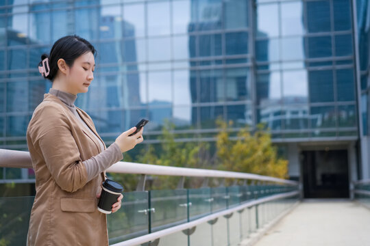 户外城市桥上查看手机的女性