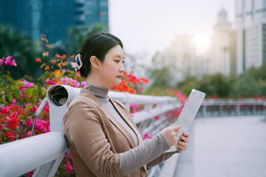 户外城市桥上的女性在看电脑邮件