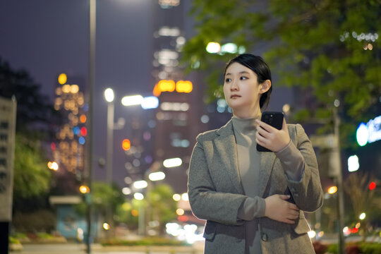 自信女性带着手机在户外行走