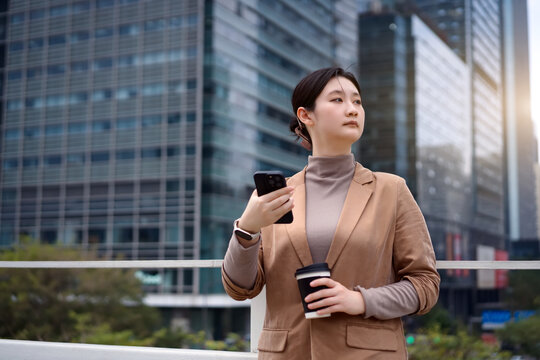 自信的女商人在城市里喝咖啡