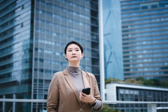 职业女性带着手机在户外行走