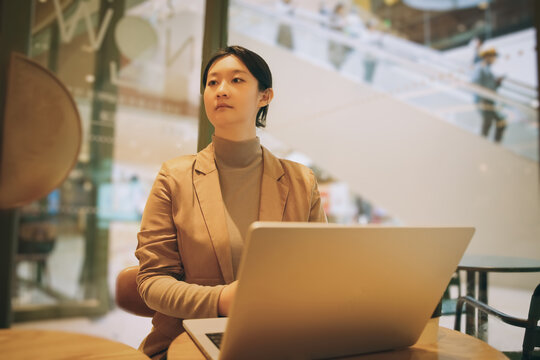 在咖啡店用笔记本办公的年轻女性