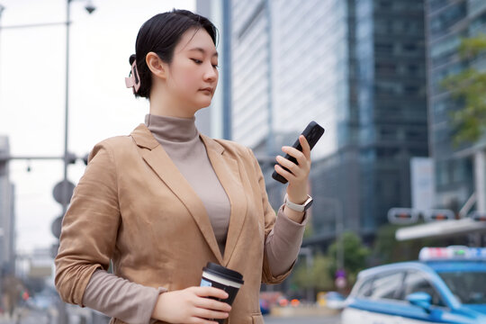 行走在街头查看手机的职业女性