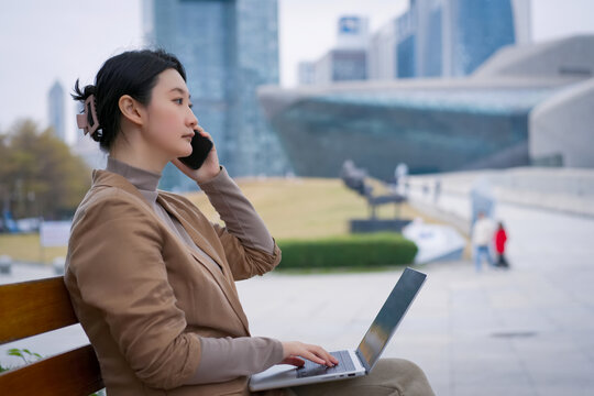 在公园长凳上职业女性用手机沟通