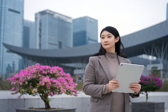 户外街上职业女性拿电脑移动办公