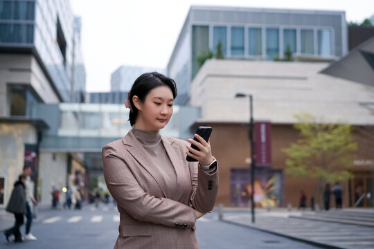 在城市街道上游览电子邮件的女性