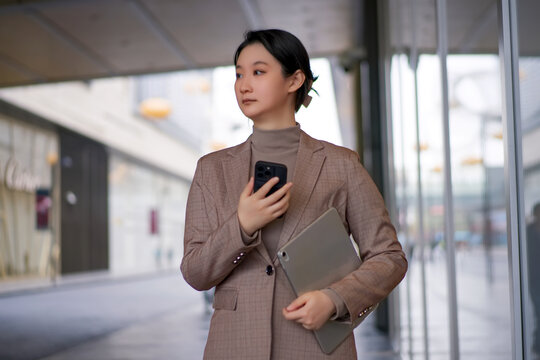 离开办公室的职业女手持平板手机