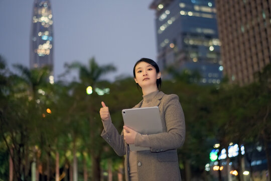 在夜晚职业女性手持平板电脑