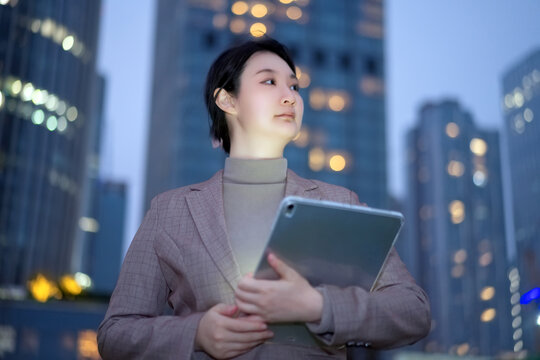 职业女性在城市夜晚里移动办公