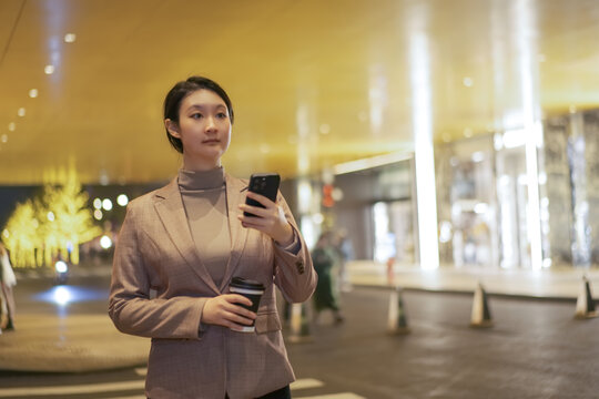 在城市街道上职业女性手拿手机