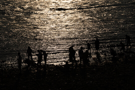 夕阳时在澜沧江边玩水人的剪影