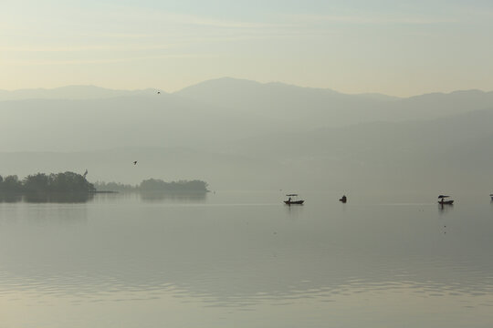 清晨泛舟邛海的渔船和飞翔的鸟儿