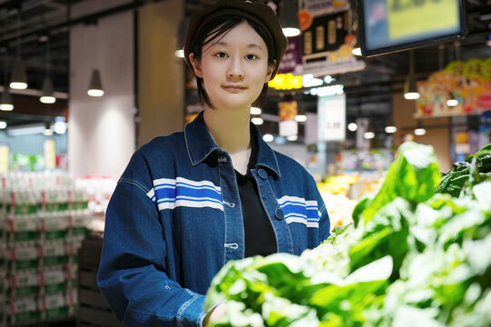 超市年轻女性检查蔬菜