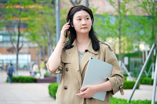 年轻女性在街道上使用通讯